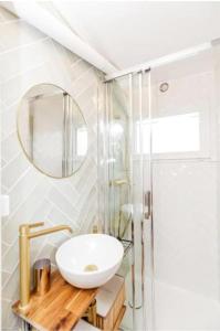 La salle de bains est pourvue d'un lavabo et d'un miroir. dans l'établissement Charmant studio lumineux calme, à Asnières-sur-Seine