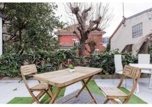 Une table et des chaises en bois sont disponibles sur la terrasse. dans l'établissement Charmant studio lumineux calme, à Asnières-sur-Seine