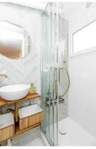 La salle de bains est pourvue d'un lavabo et d'une douche en verre. dans l'établissement Charmant studio lumineux calme, à Asnières-sur-Seine