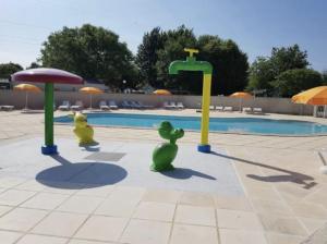 two toy animals are playing in front of a pool at Les Mobilhomes d'Edit - Pour 2 à 12 personnes in Boofzheim