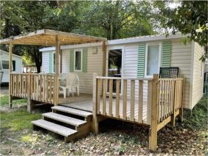 a mobile home with a deck and a gazebo at Les Mobilhomes d'Edit - Pour 2 à 12 personnes in Boofzheim