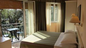a bedroom with a bed and a balcony at Hotel Ausonia in Follonica