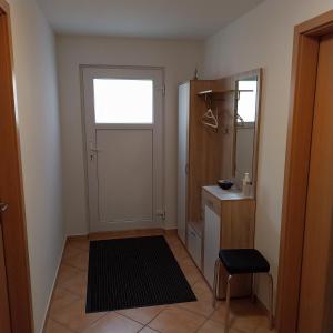 Zimmer mit einer Tür, einem Fenster und einem Stuhl in der Unterkunft Souterrainwohnung in Gottmadingen