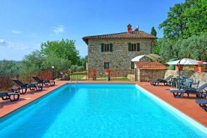 a pool with chairs and a house in the background at Villa Quercina in Pieve a Presciano