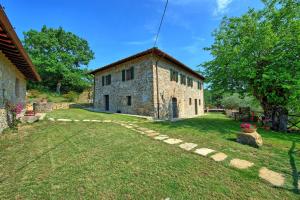 an external view of a stone house with a yard at Villa Quercina in Pieve a Presciano