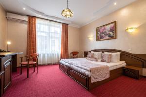 ein Hotelzimmer mit einem Bett und einem Tisch in der Unterkunft Edem Hotel Lviv in Lwiw