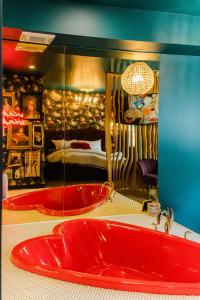 a red bath tub in a room with a bedroom at The Grove Motel in Colchester