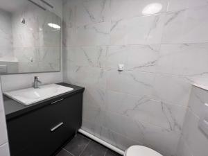 a white bathroom with a sink and a toilet at HOTEL LES PORTES DE PARIS in Ivry-sur-Seine