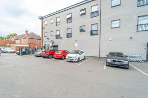 a group of cars parked in a parking lot next to a building at Contemporary near city apartment, free parking and wifi, perfect for contractors in Wolverhampton