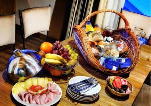 une table avec une corbeille de fruits et des assiettes de nourriture dans l'établissement Chalets Jasná Collection - Apartments, à Demänovská Dolina