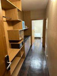 a small kitchen with wooden shelves and a hallway at Apartment Katrin Harrachov Resident - Sauna world free in Harrachov +27 photos