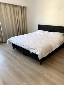 1 dormitorio con 1 cama grande con sábanas blancas en Une belle étage à Stockel en Bruselas
