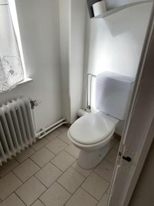 bagno con servizi igienici bianchi e radiatore di Une belle étage à Stockel a Bruxelles