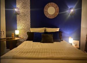 - une chambre avec un grand lit et un mur bleu dans l'établissement L’ escale, à Saumur