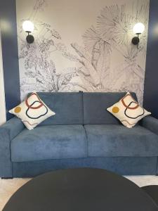 - un canapé bleu avec deux oreillers dans le salon dans l'établissement Charmant studio cosy centre-ville - RUE4, à Rueil-Malmaison