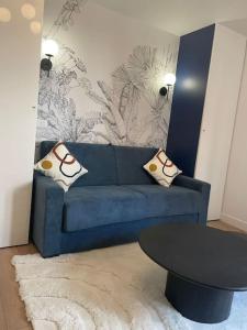 - un salon avec un canapé bleu et une table dans l'établissement Charmant studio cosy centre-ville - RUE4, à Rueil-Malmaison