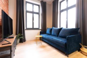 a blue couch in a living room with windows at Central LOFT in Nowe Miasto Lubawskie
