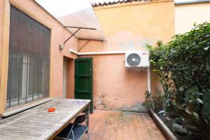 eine Außenterrasse mit einem Tisch und einem Fenster in der Unterkunft Tourist House Bologna Pratellino - Self Check-in in Bologna