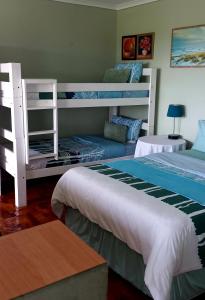 a bedroom with two bunk beds and a couch at Wild Coast Grosvenor Holiday Home in Lusikisiki