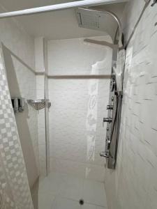 Baño blanco con ducha con puerta de cristal en Modern Apartment in Mendoza Capital en Mendoza