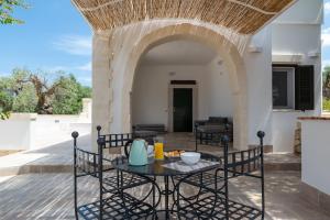 a patio with a table and chairs and an archway at Villa Incanto con terrazza e piscina by Wonderful Italy in Ostuni