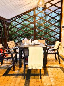 a patio with a table and chairs and a glass wall at Mazurska Chatka in Srokowo