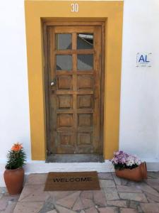 una puerta con una señal de bienvenida frente a un edificio en Margarida Guest House, en Almada