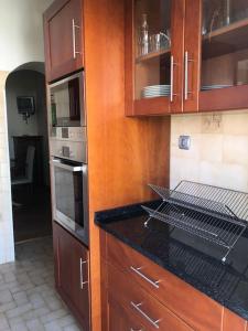 a kitchen with wooden cabinets and a counter top at Margarida Guest House in Almada