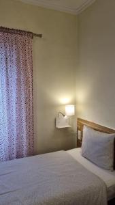 a bedroom with a bed with a curtain and a lamp at Margarida Guest House in Almada