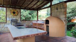 una cocina al aire libre con horno en un edificio de piedra en Hacienda Raíces, en Subachoque