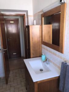 a bathroom with a sink and a mirror and a door at Margarida Guest House in Almada