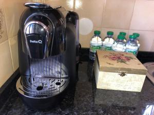 a blender sitting on a counter next to bottles of water at Margarida Guest House - Lisbon South by Rosado in Almada