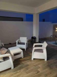 um quarto com três cadeiras brancas e uma mesa em Espectacular alojamiento em Punta Cana