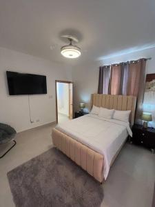 um quarto com uma cama grande e uma televisão de ecrã plano em Espectacular alojamiento em Punta Cana