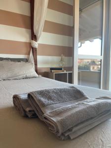 ein Schlafzimmer mit einem Bett mit einer Decke und einem Fenster in der Unterkunft Villetta Rovizza in San Martino della Battaglia