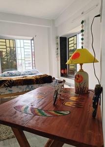 Zimmer mit Tisch und Lampe in der Unterkunft Traveller's Nest in Shiliguri