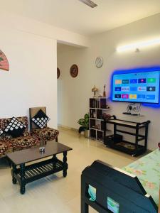 a living room with a large flat screen tv on the wall at Raga Homestay 2.0- Urban Comfort in Guwahati