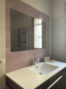 ein Badezimmer mit Waschbecken und großem Spiegel in der Unterkunft Villetta Rovizza in San Martino della Battaglia