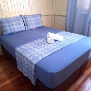 Una cama azul con dos toallas encima. en Casa D&R, en Canela