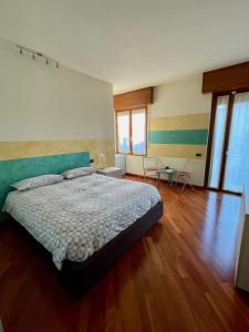 1 dormitorio con 1 cama, suelo de madera y ventanas en B&B Adelaide en Brescia