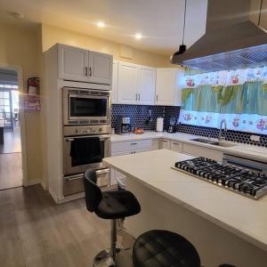 a kitchen with white cabinets and a stove top oven at Casa treacy in Newark
