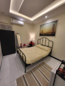 1 dormitorio con 1 cama y una pintura en la pared en استديو سرير ماستر ودخول ذاتي بحي الملقا, en Riad