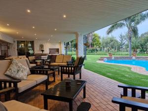 an outdoor patio with furniture and a swimming pool at Villa Sardinia Guest House in Midrand