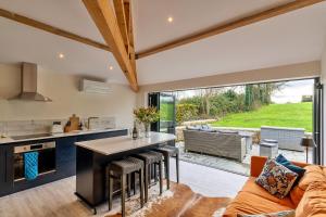 a kitchen and living room with a couch and a table at Finest Retreats - The Stables at Lilac Cottage in Hawling