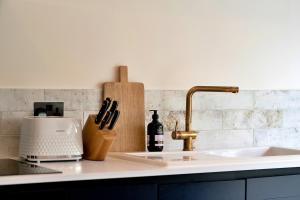 a kitchen counter with a knife block and a sink at Finest Retreats - The Stables at Lilac Cottage in Hawling