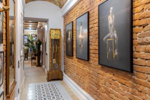 un corridoio con un muro di mattoni con quadri incorniciati di Художня резиденція Львова a Lviv Altre 23 foto