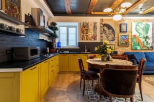 リヴィウにあるХудожня резиденція Львоваのキッチン(黄色のキャビネット、テーブル、椅子付)