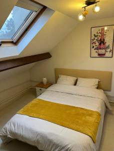 - une chambre avec un lit et une couverture jaune dans l'établissement LE CHAMPENOIS, Avenue de Champagne, à Épernay