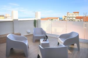 three chairs and a table on a balcony with a view at Ruffini Rooms in Termoli