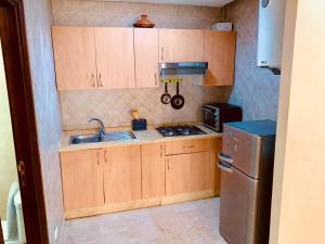 una piccola cucina con armadi in legno e lavandino di Apparts KARAMI a Marrakech